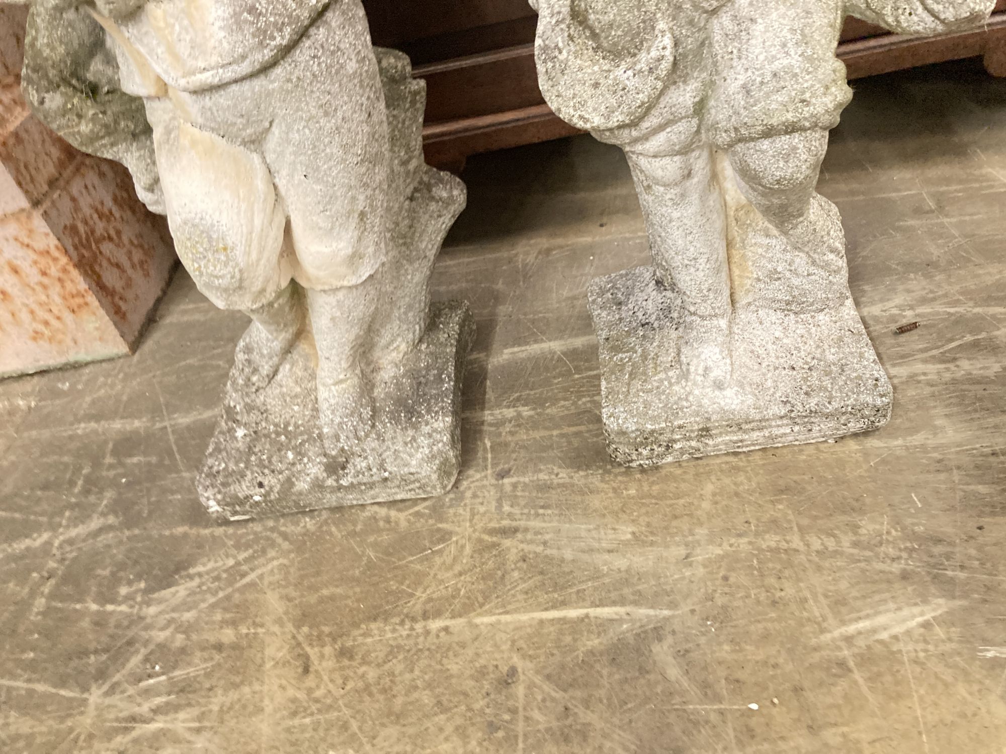 A pair of reconstituted stone garden ornaments, boys with wheatsheaves, larger 87cm high